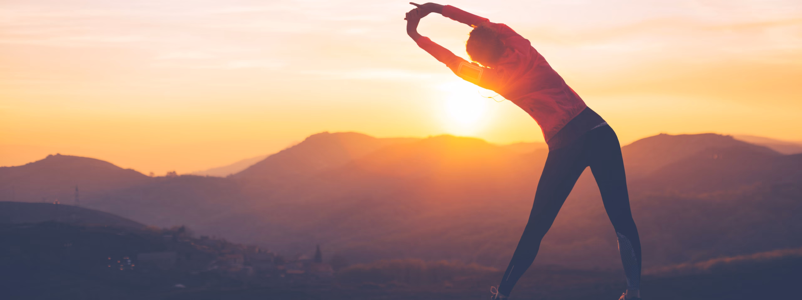Frau beim Stretching im warmen Abendlicht